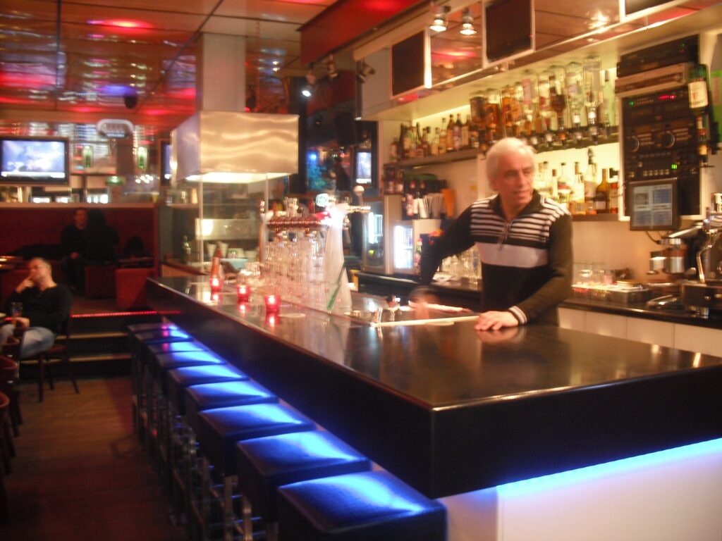 De lange bar van St. Pauls met blauw verlichte barkrukken