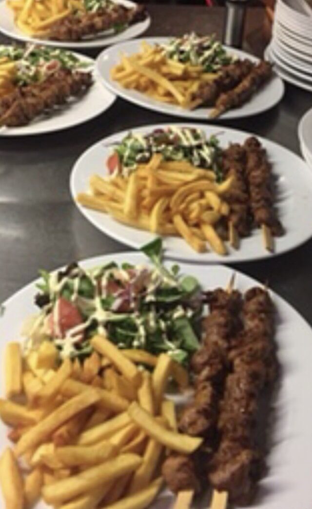 Borden van de grill met friet en salade, klaar om uit te serveren